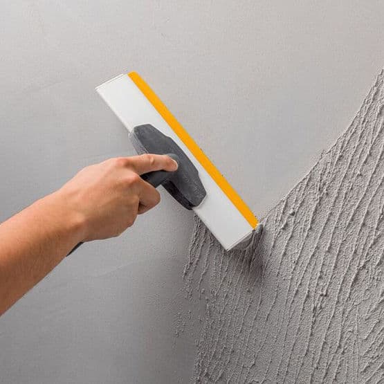 Application d’enduit de finition sur un mur
